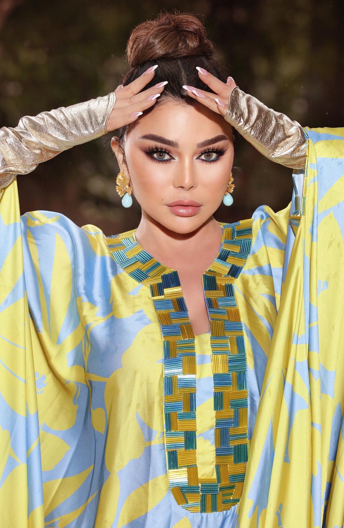 هيفاء وهبي بأقراط ضخمة التصميم من الذهب الأصفر ومرصّعة بأحجار ملوّنة باللون الأزرق