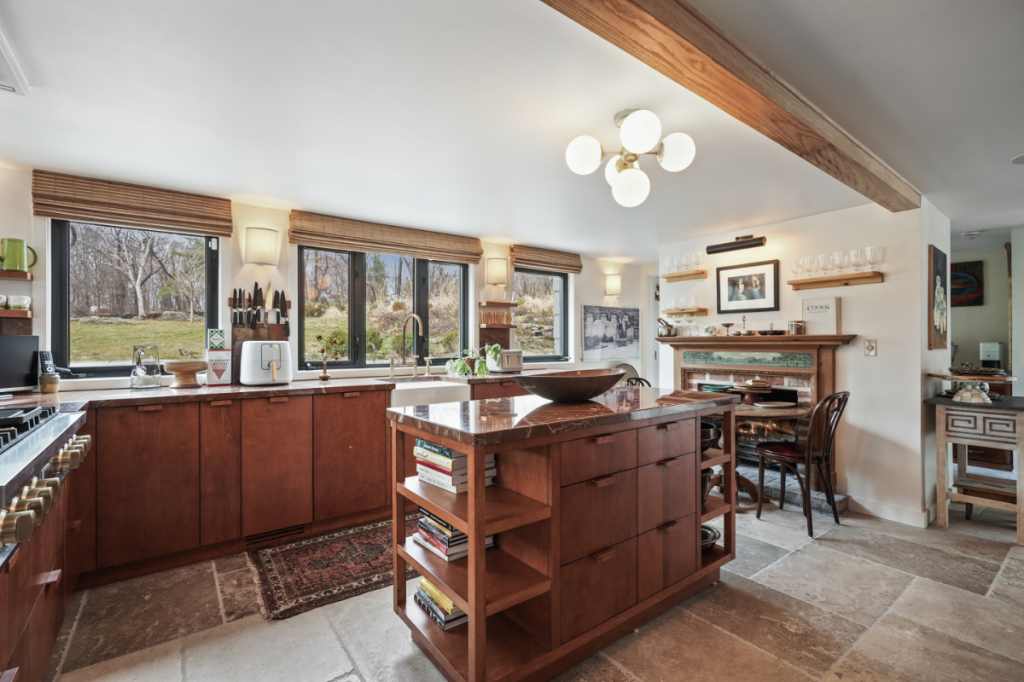 يعتمد المطبخ على الخزائن الخشبية والأرضيات الحجرية وجزيرة مركزية مميزة