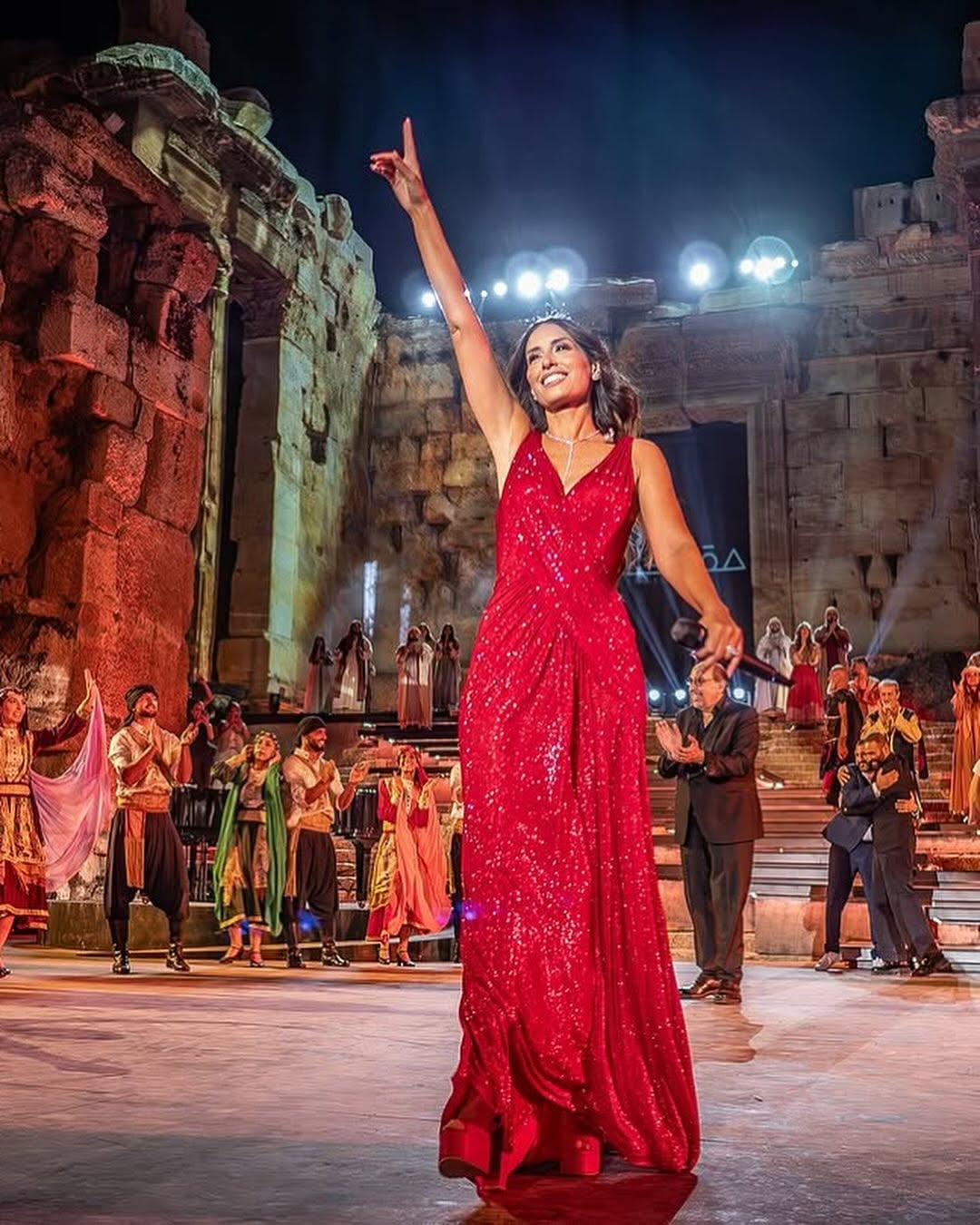 هبة طوجي بالفستان الأحمر البرّاق بين أعمدة قلعة بعلبك