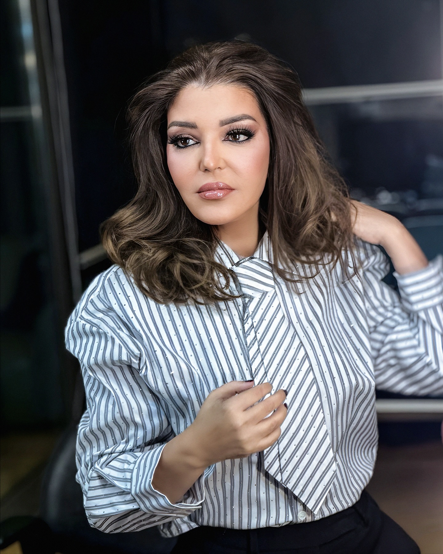 إطلالة كلاسيكية بمكياج سموكي وشعر كيرلي