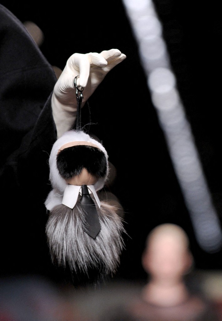 كارا ديليفين تحمل تصميمًا لدار Fendi، يمثل مصمم الأزياء كارل لاغرفيلد، كجزء من مجموعات أسبوع الموضة في ميلانو لخريف وشتاء 2014