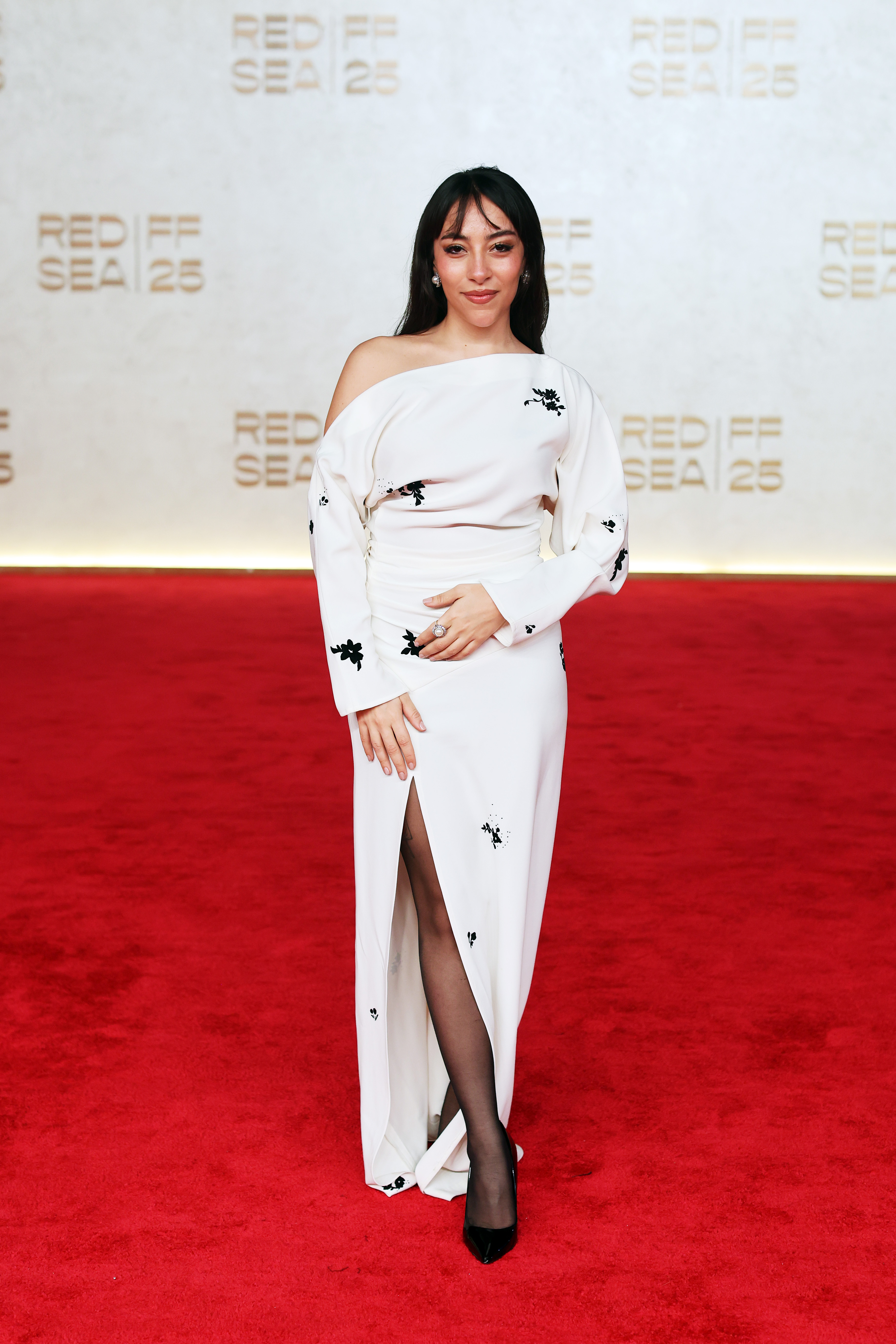 سارة طيبة ترتدي فستانا ناعما باللون الأبيض بكتف مائل