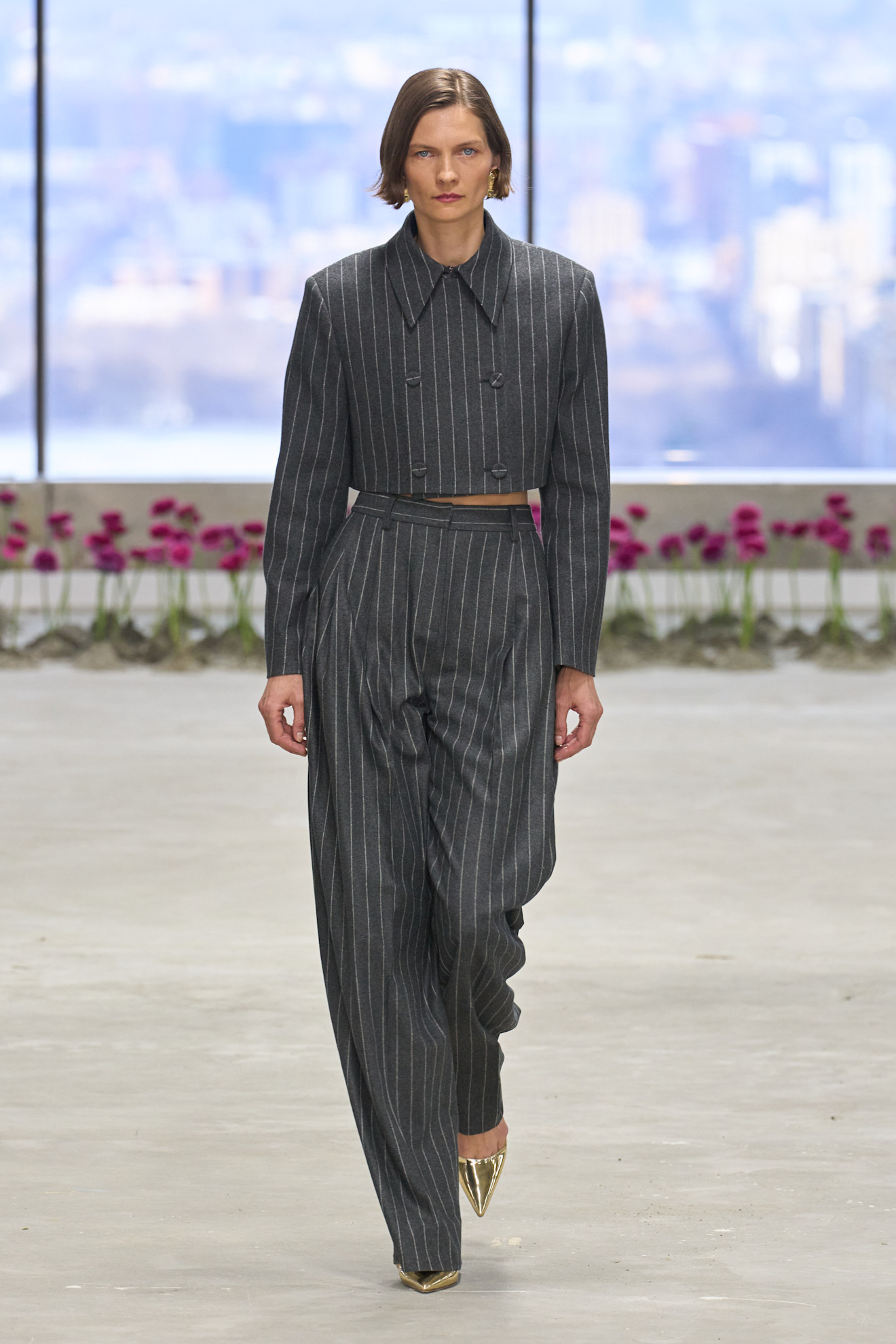 سترة قصيرة دوبل بريستد مع سروال رمادي بخطوط عمودية من Carolina Herrera، لإطلالة أنيقة تجمع بين الكلاسيكية والحداثة