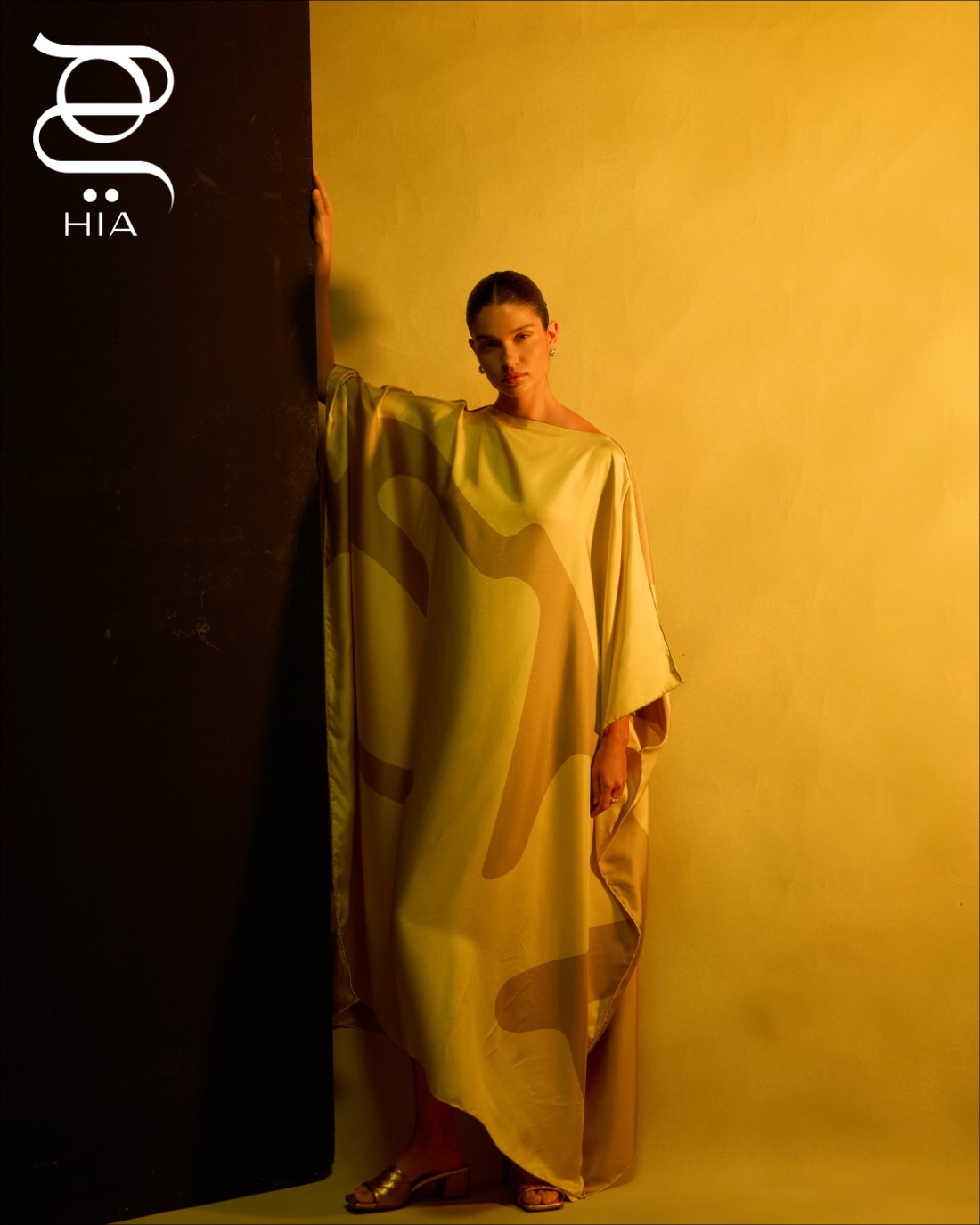 قميص حريري مع حزام باللون العنابي وسروال أسود ‏ حذاء ميول "باركو" ‏PARCO‏ باللون الذهبي ‏ جميعها من دار "بوتيغا فينيتا" ‏Bottega Veneta