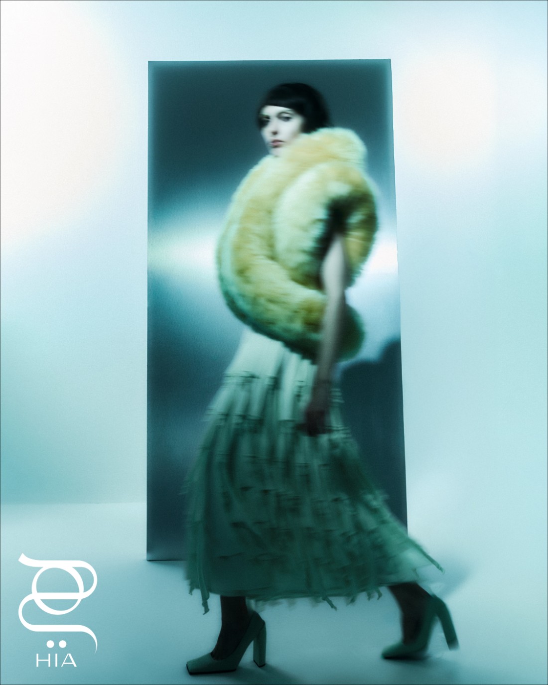 من "علية" Alaïa، سترة بلا أكمام من صوف "شيرلينغ"، وتنورة محبوكة بمزيج حريري، وحذاء جلديّ برأس مستدق.
