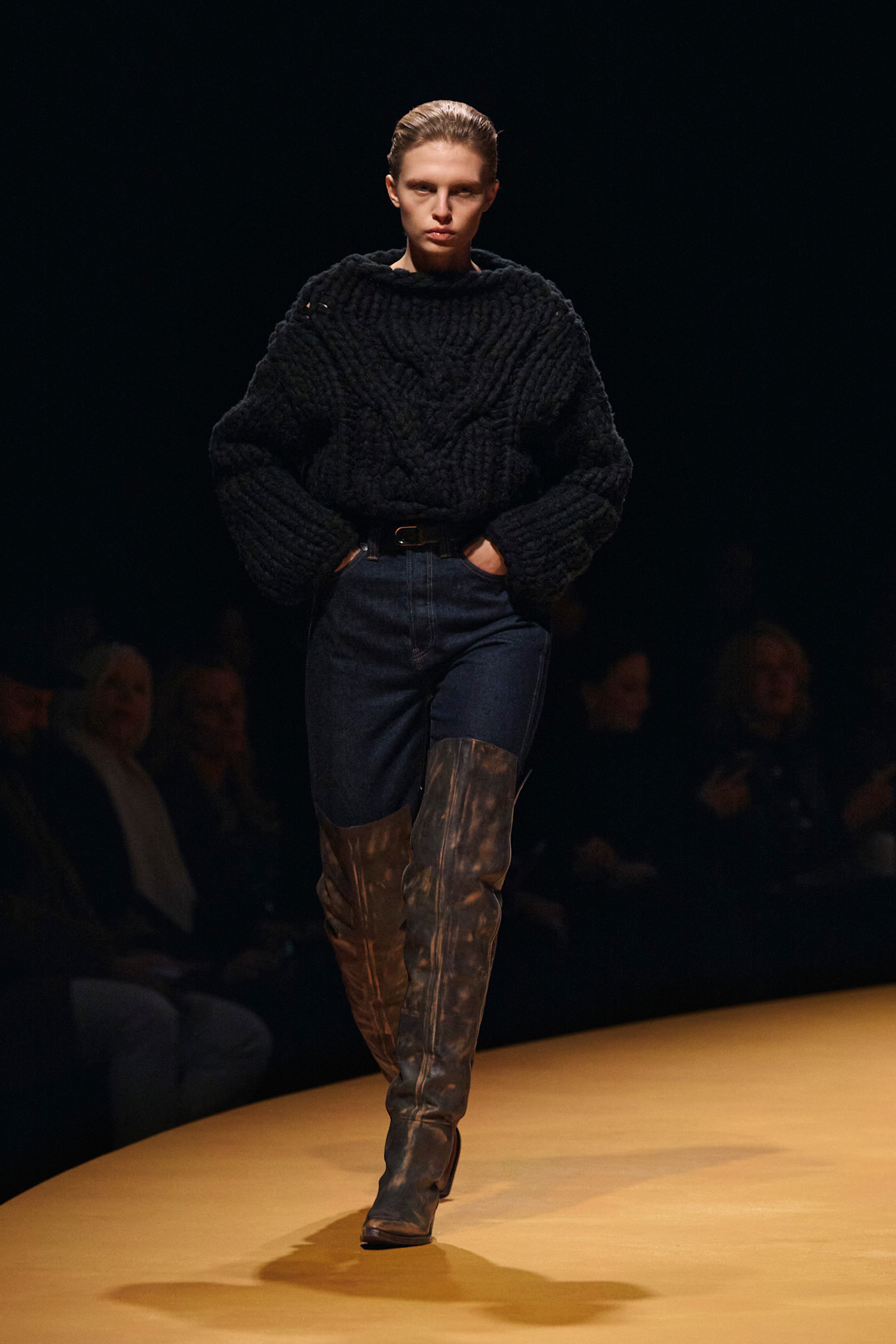 حذاء طويل باللون البني بأسلوب رعاة البقر من Khaite نُسق مع سروال جينز وكنزة صوفية لإطلالة كاجوال أنيقة وعملية