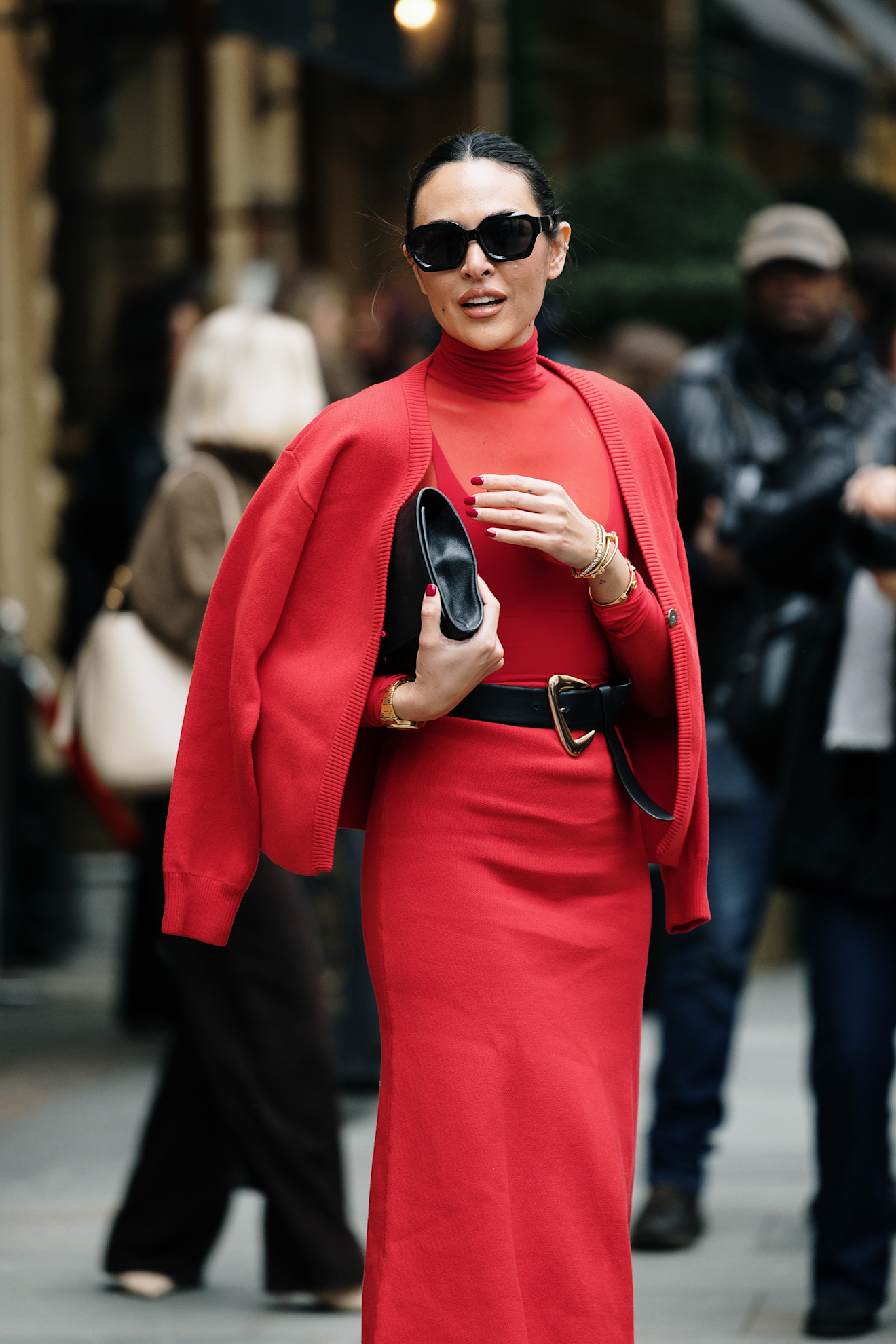 إطلالة أحادية اللون بالأحمر الصارخ تجمع بين الجرأة والأناقة، مع لمسات سوداء من الحزام والحقيبة والنظارات تضيف التوازن المثالي.