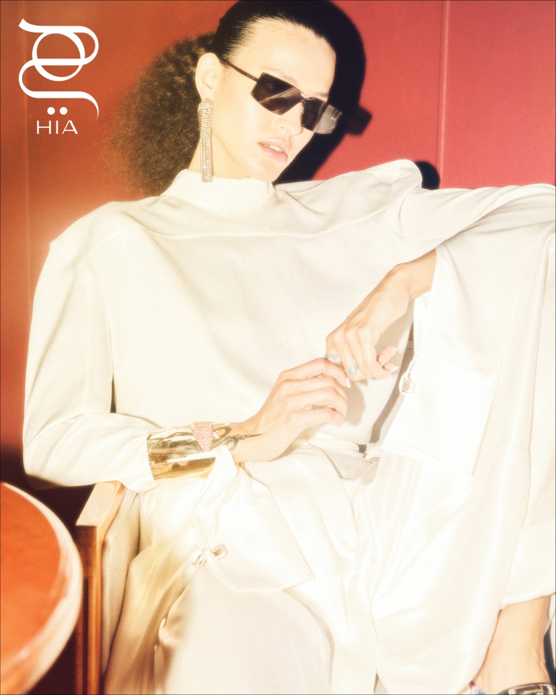 طقم مؤلف من قميص وسروال مع حذاء من دار "لويس فويتون" Louis Vuitton  إسوارة وخواتم من مجوهرات "بالعربي" Bil Arabi  أقراط من "رابان" Rabanne ونظارات شمسية من "ماكس مارا" Max Mara