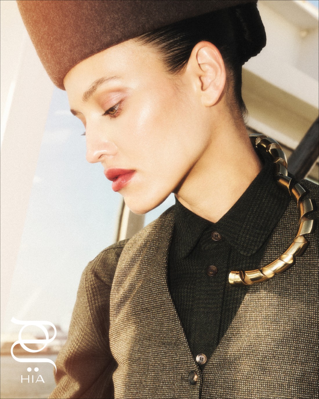 قميص داكن وسترة رسمية مع قبعة من دار "لورو بيانا" Loro Piana  عقد صلب معدني ذهبي من دار "رابان" Rabanne