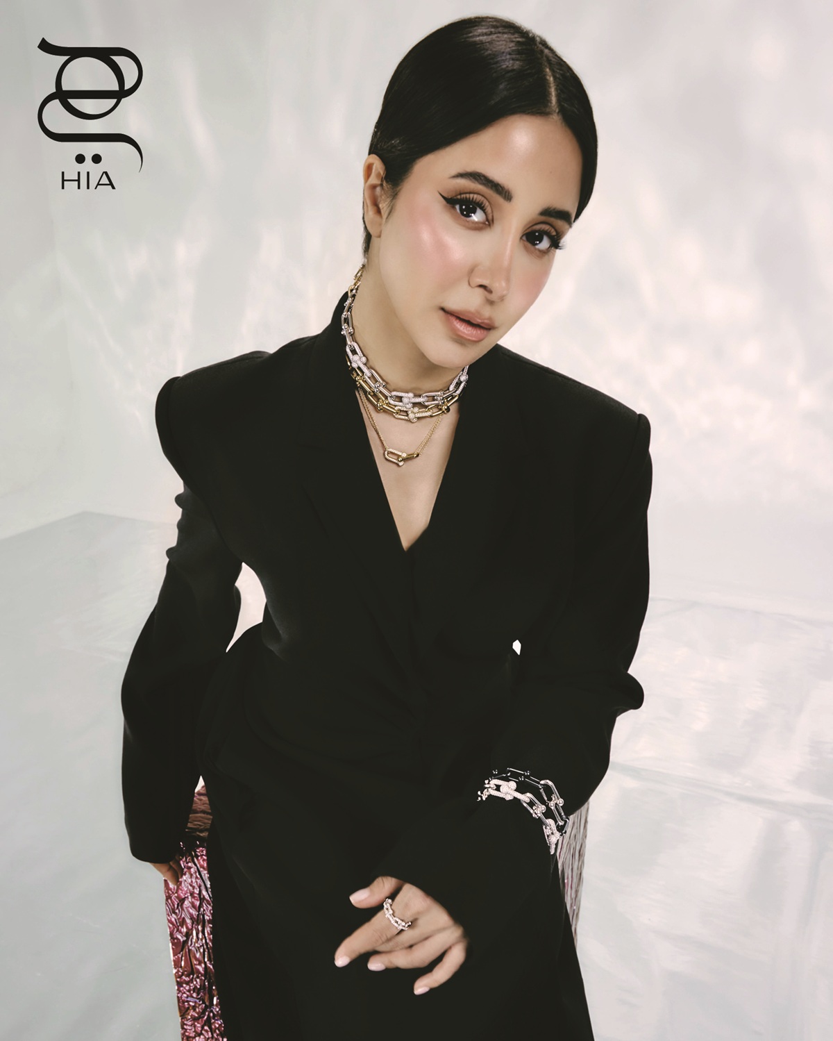 من مجموعة TIFFANY HARDWEAR عقود بالذهب الأصفر والأبيض، قلادة وأساور بالذهب الأبيض والبلاتين، وخاتم صغير بالذهب الأبيض والماس جميعها من "تيفاني أند كو" .TIFFANY & CO. فستان من "نون باي نور" Noon By Noor