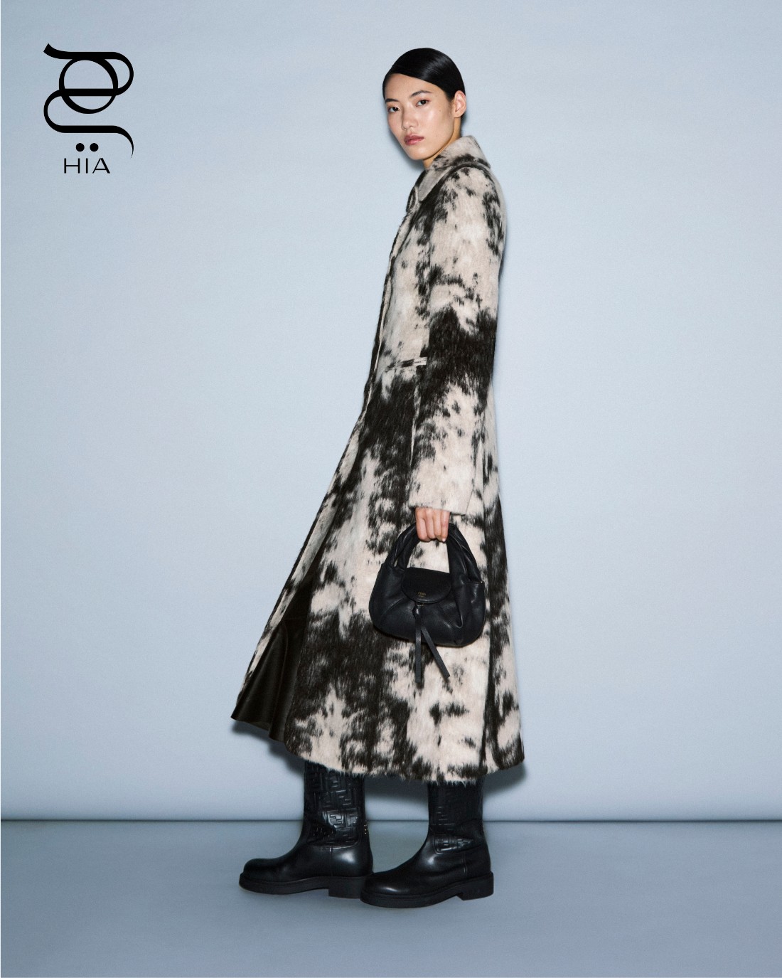 معطف صوفي باللونين الأسود والأبيض، حقيبة “ميني سباي" Mini Spy باللون الأسود، وحذاء “فيلو” Filo، جميعها من “فندي" Fendi