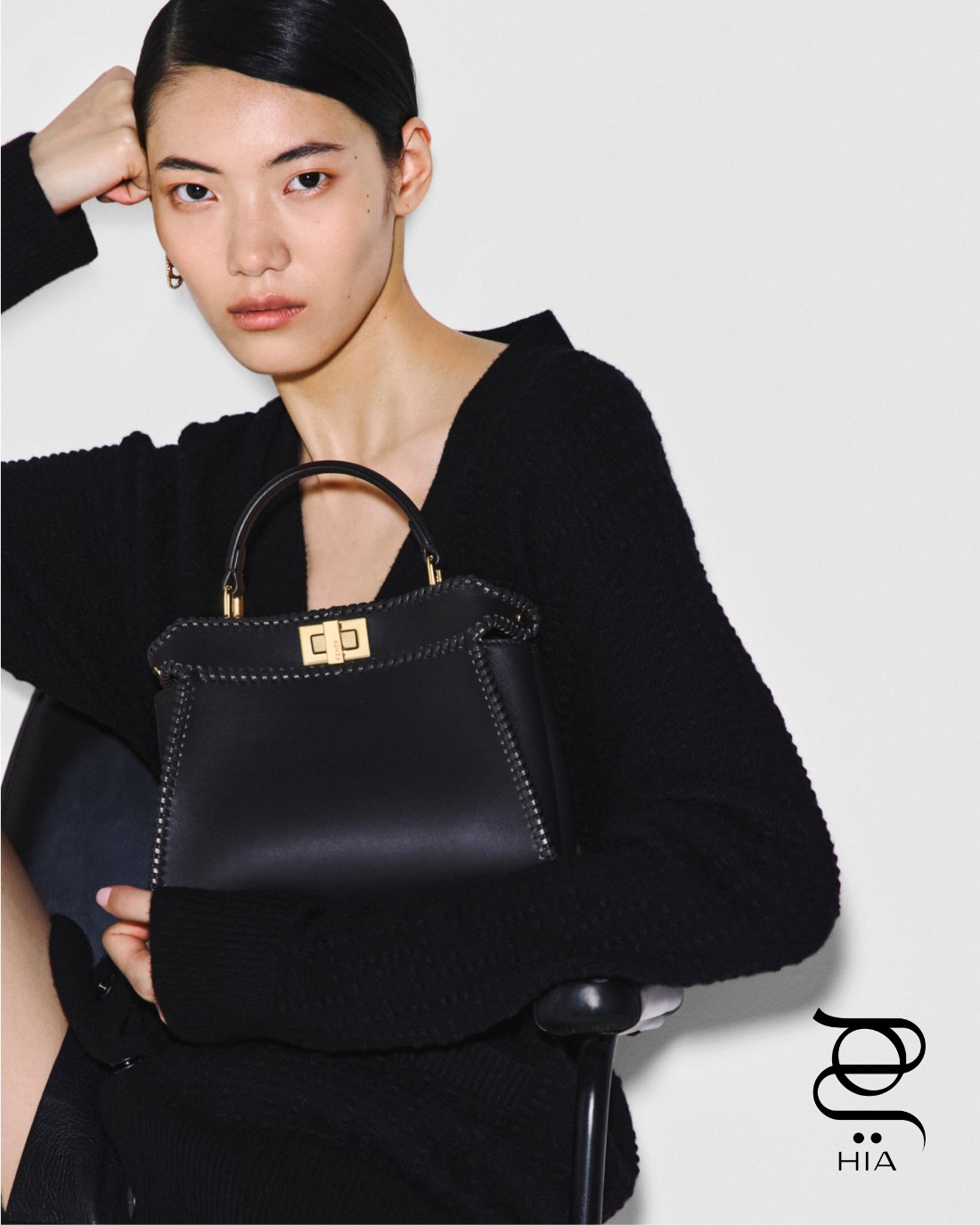 كارديغان أسود بنقشة FF، وحقيبة “ميني بيكابو" Mini Peekaboo، كلاهما من “فندي" Fendi