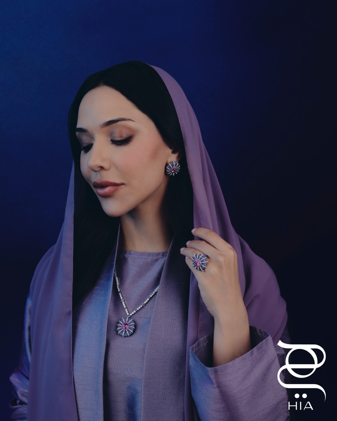 من طقم COLOSSEUM من مجموعة المجوهرات الراقية ILLUMINATED WONDERS: عقد وسوار وخاتم وأقراط أذن مرصعة بالصفير الوردي والأزرق والماس، جميع المجوهرات من "معوّض" MOUAWAD، عباءة وشيلة من "سيرب" SERRB