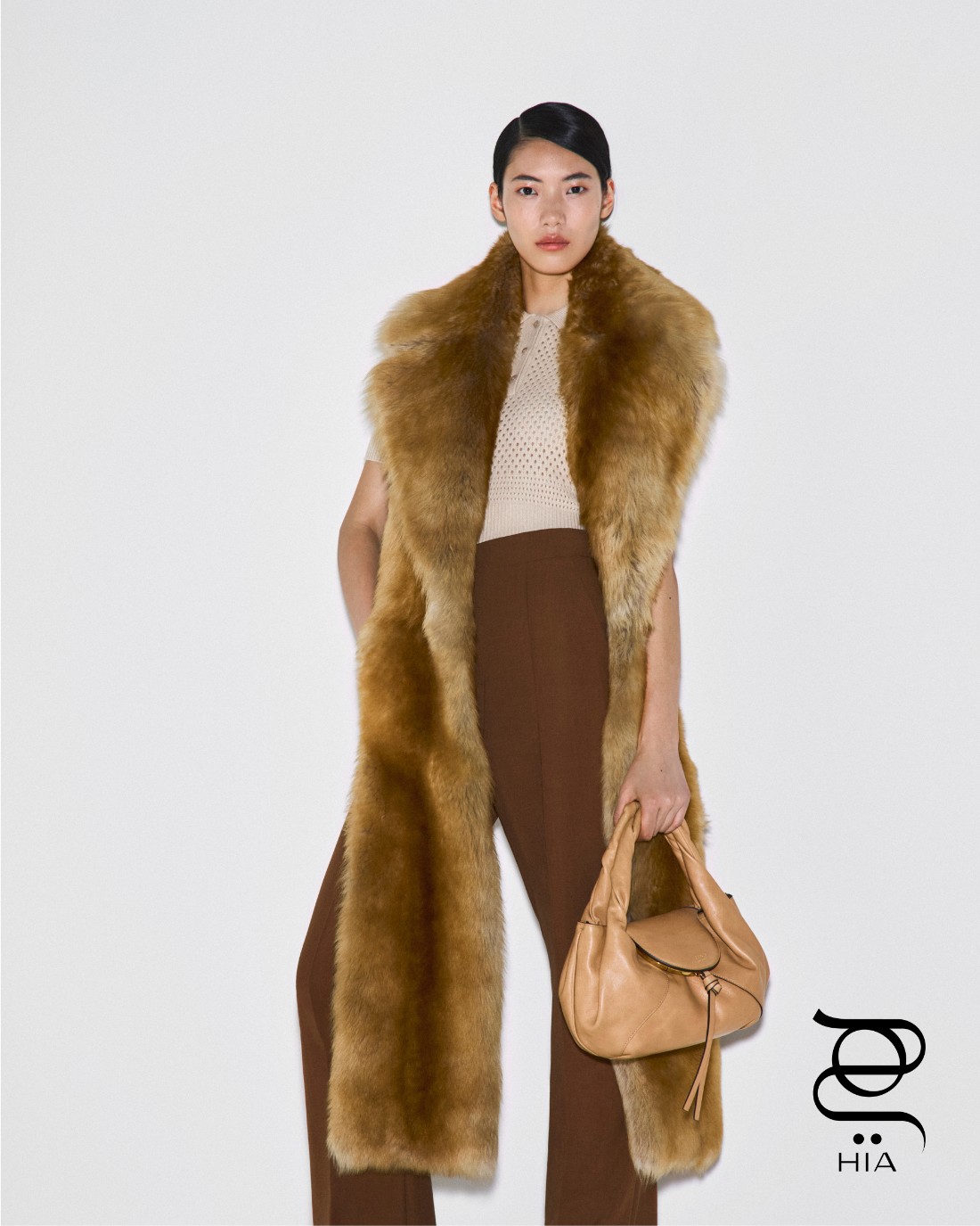 قميص بولو، وشاح شيرلينغ، سروال باللون البني، وحقيبة “سباي” Spy صغيرة باللون البيج، جميعها من “فندي" Fendi