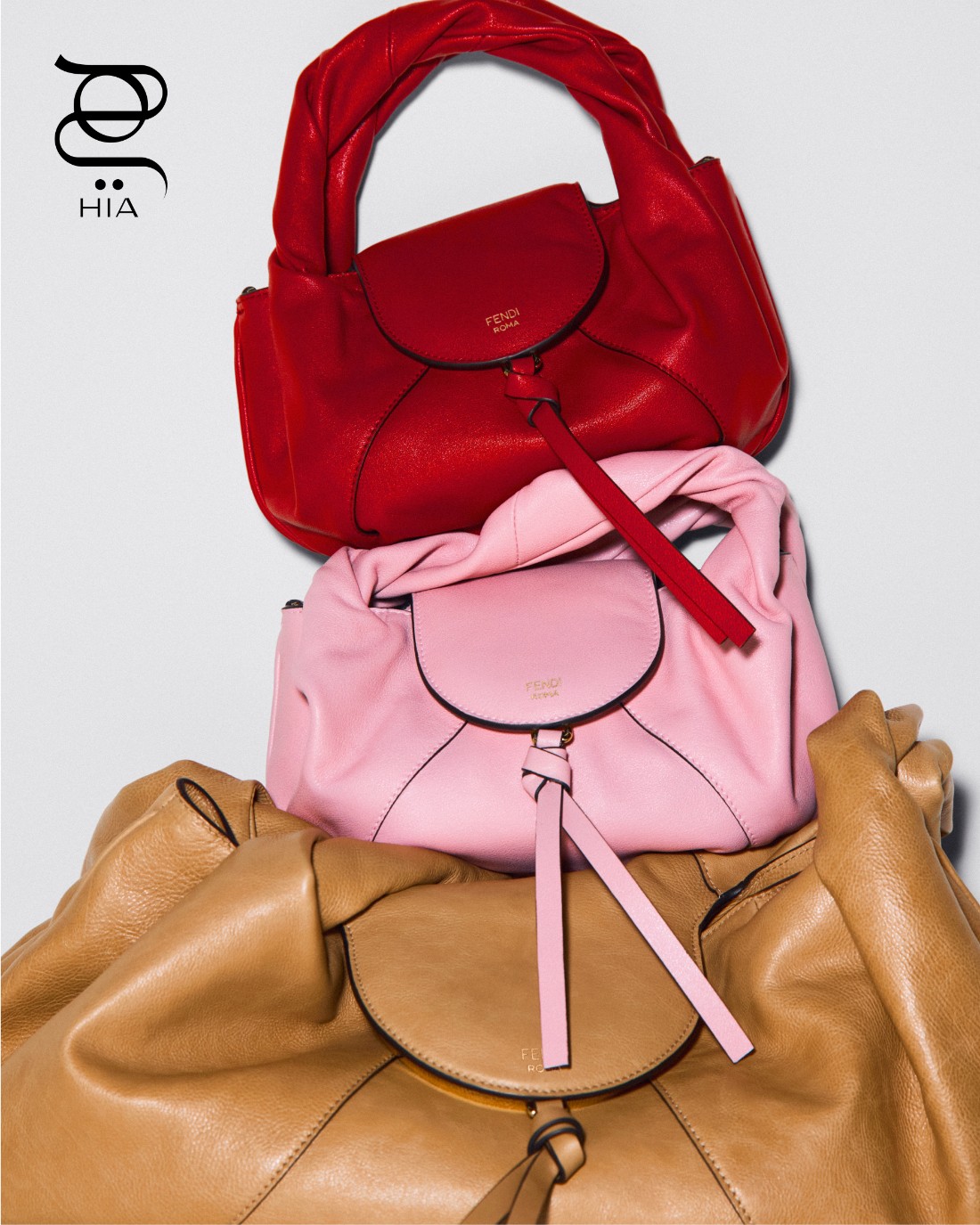 حقيبة “ميني سباي” Mini Spy باللون الأحمر، حقيبة “ميني سباي" Mini Spy باللون الوردي الفاتح، وحقيبة “سباي” Spy باللون البيج، جميعها من “فندي" Fendi