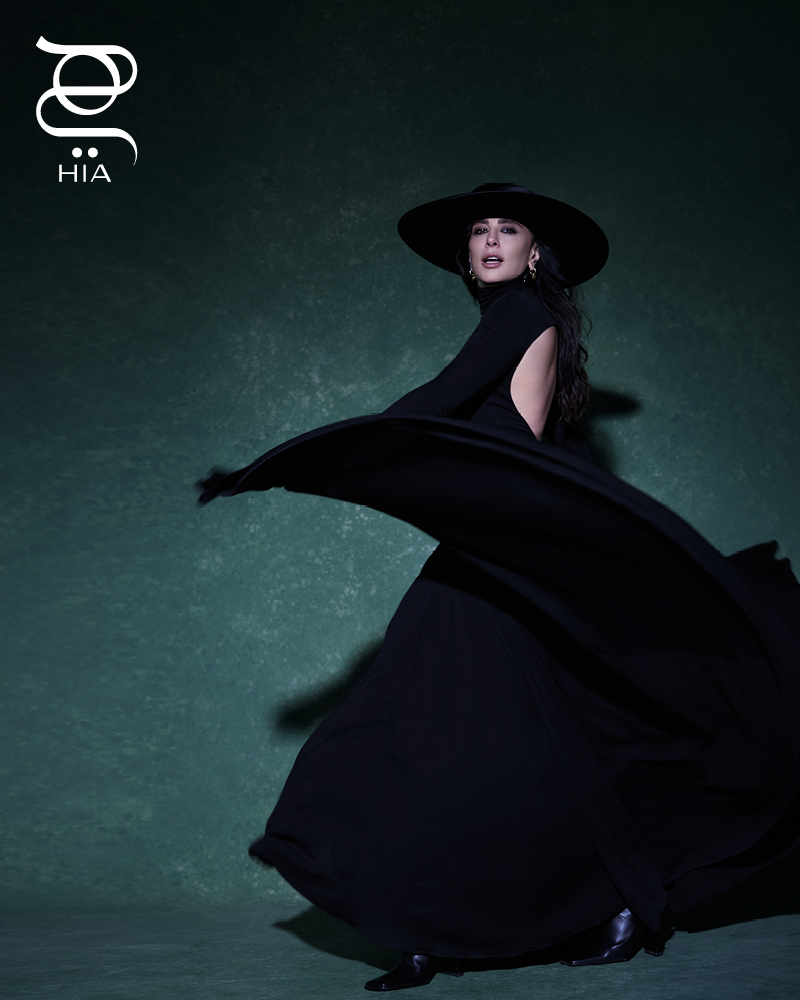 أقراط أذن مزدوجة LOVE بالذهب الأصفر، أساور LOVE UNLIMITED بالذهب الأصفر وبالذهب الأبيض، أساور LOVE بالذهب الأبيض والماس، جميع المجوهرات من "كارتييه" CARTIER فستان طويل وجزمة عالية الساق من "علية" Alaia، قيعة واسعة من "كريستينا فيديلسكايا" Kristina Fidelskaya