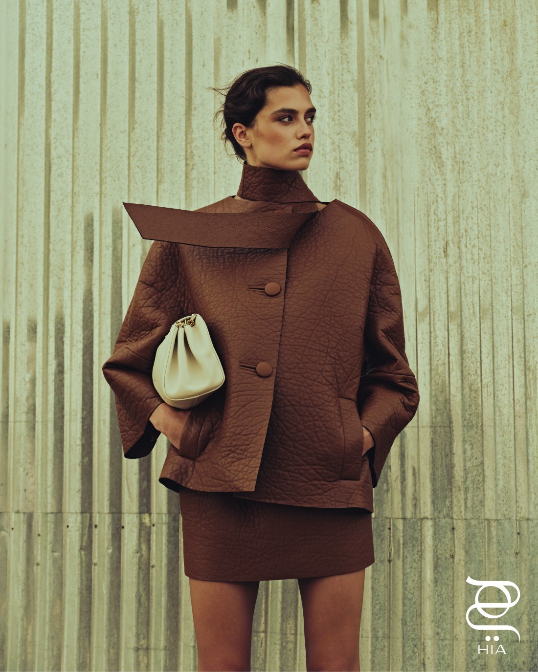 تنورة من جلد النابا، وحقيبة "تمولت" Tumulte، جميعها من "برادا" Prada