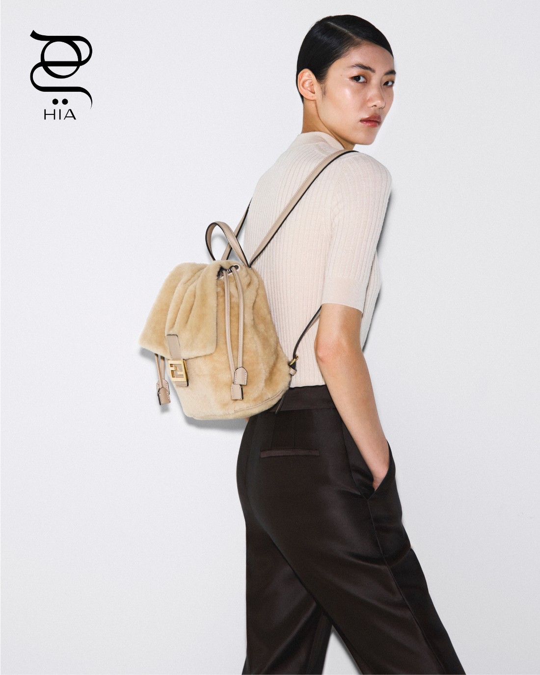 سترة صوفية، سروال باللون البني، وحقيبة ظهر من الشيرلينغ، جميعها من “فندي" Fendi