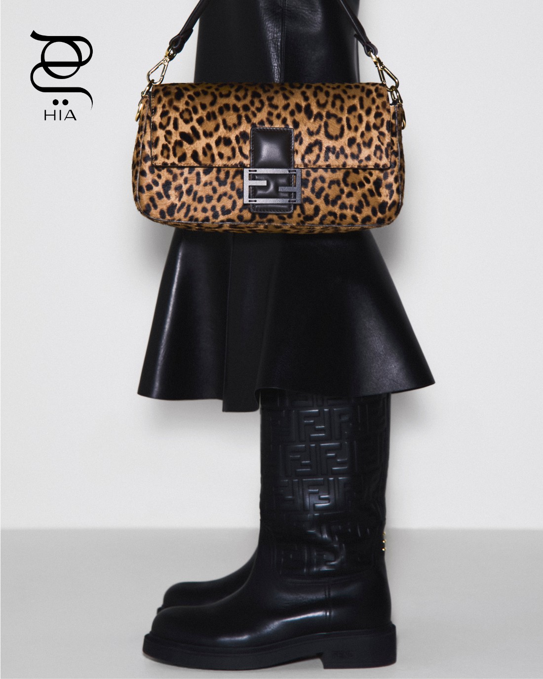 تنورة جلدية باللون الأسود، حذاء “فيلو" Filo أسود، وحقيبة “باغيت" Baguette، جميعها من “فندي" Fendi