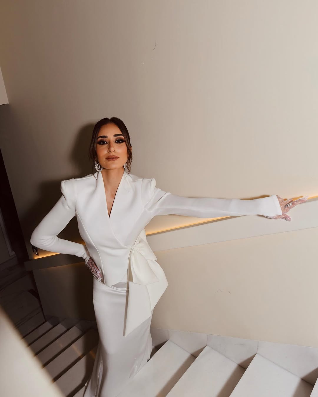 أمينة خليل بتنورة حريرية ماكسي موصولة بذيل متدلي وجاكيت مجسم مغلق بعقدة فيونكة
