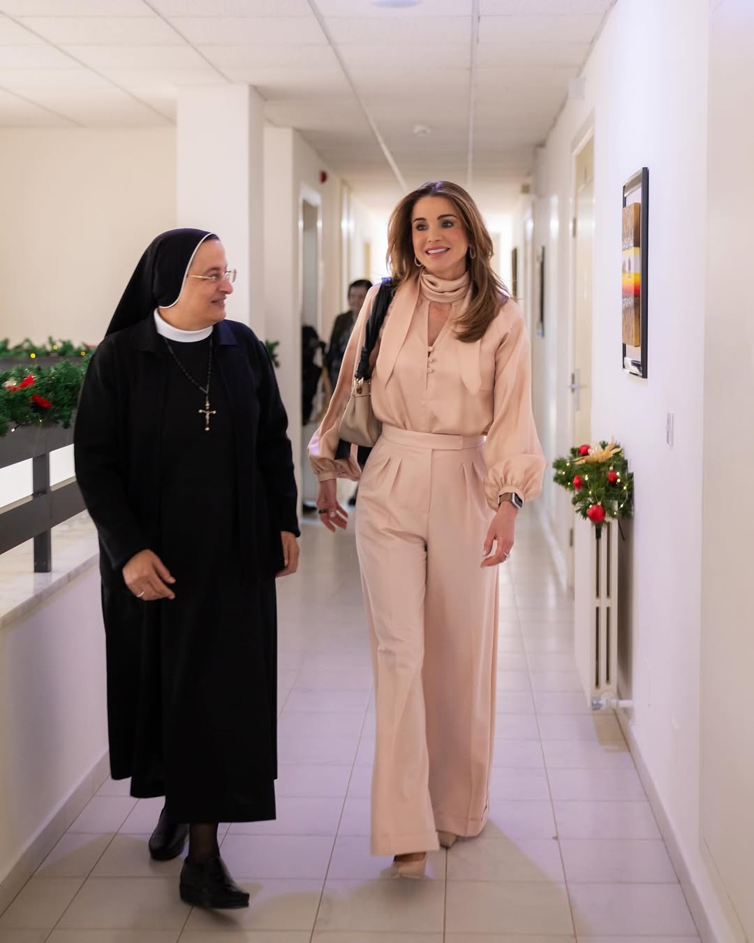 الملكة رانيا بإطلالة مونوكروم باللون الزهري الشاحب من بنطلون واسع وبلوزة مريحة