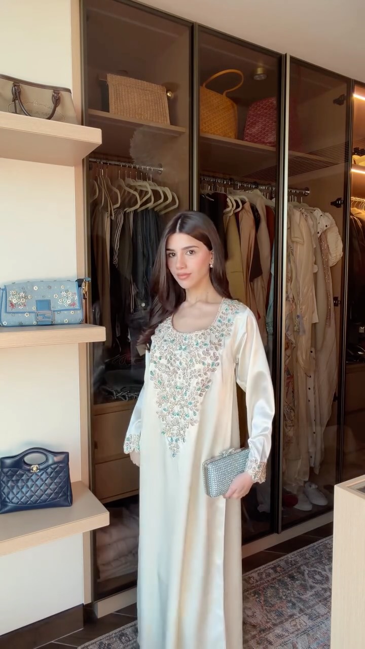 سيدرا عمارة بثوب حريري طويل باللون الأبيض بقصة واسعة تخفي ملامح القوام