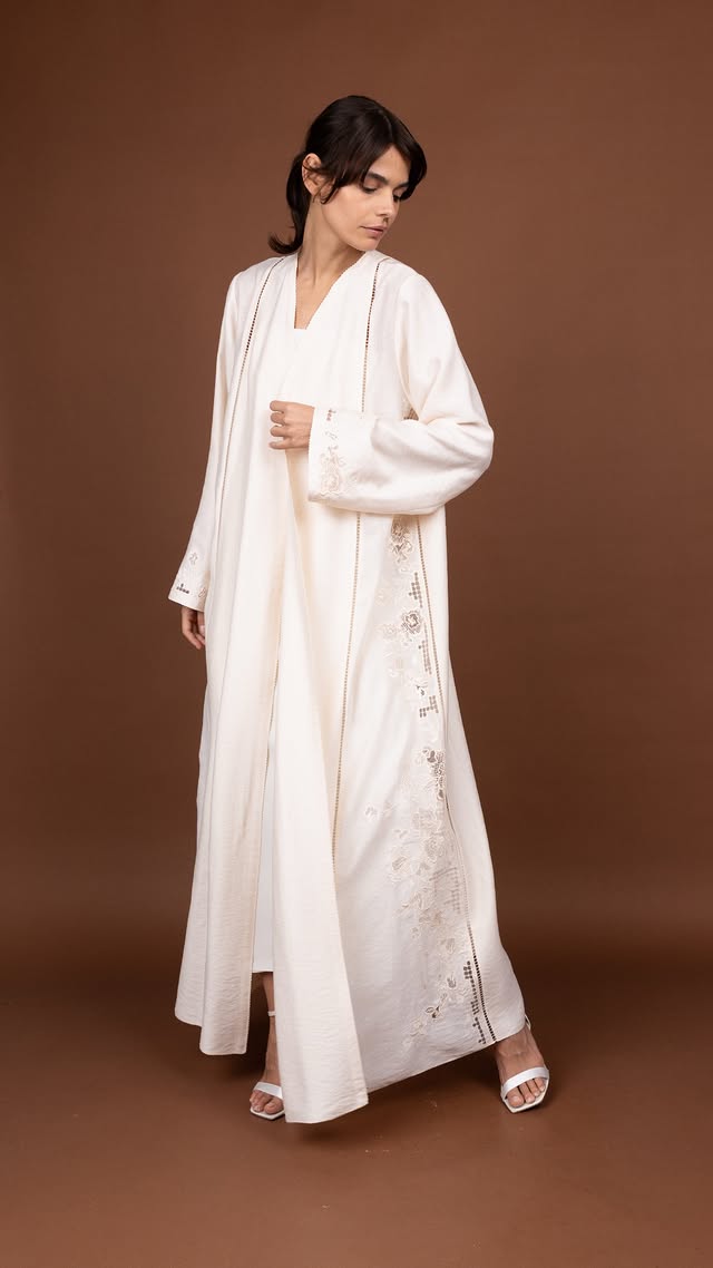 mauzanخيوط دانتيل تزين العباءة البيضاء من