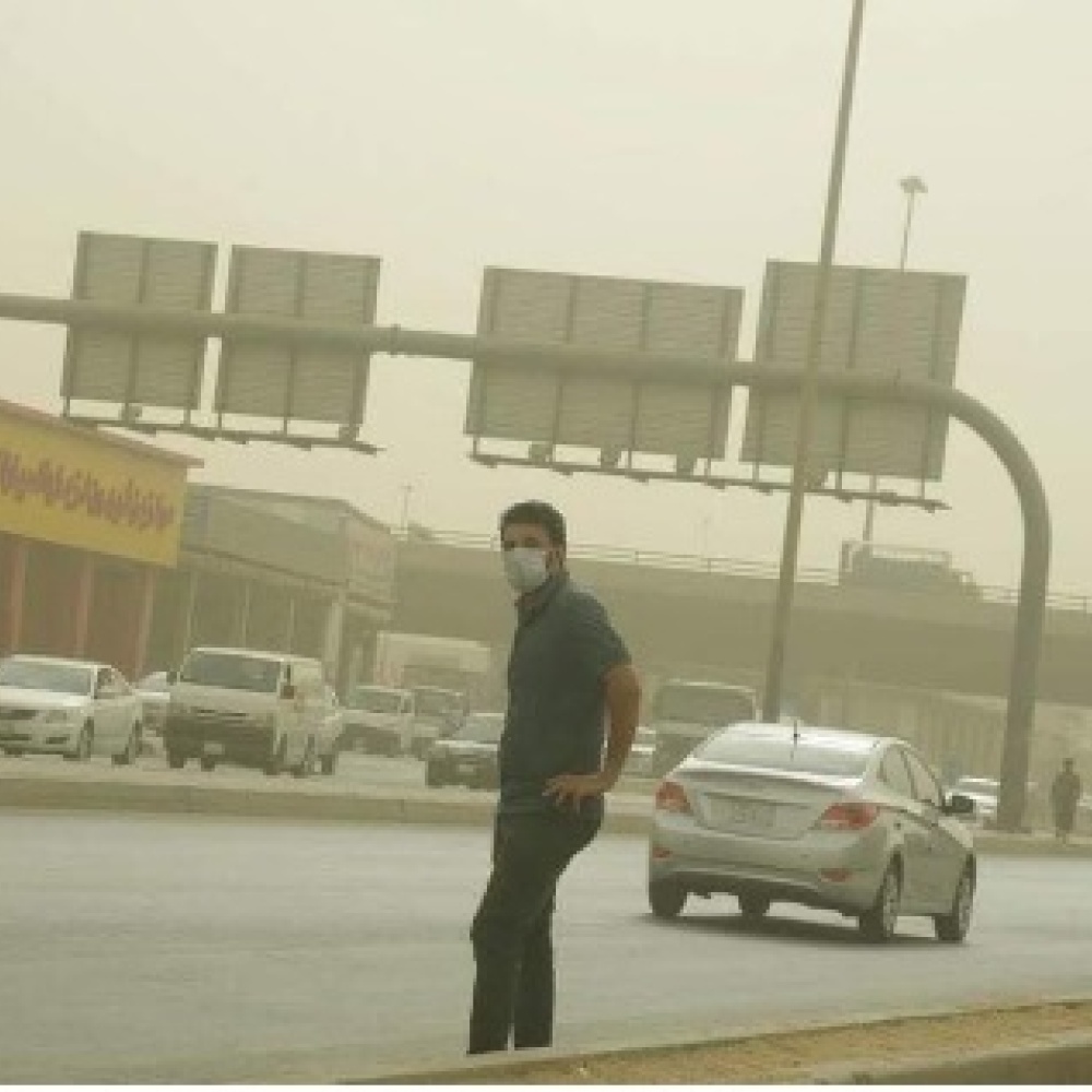 أحد المواطنين يحاول عبور الشارع وسط الغبار