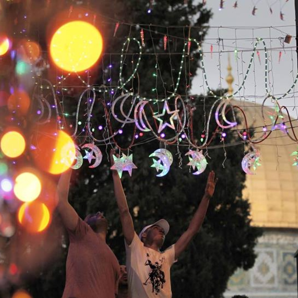 شباب يضعون اللمسات الأخيرة لزينة رمضان في القدس