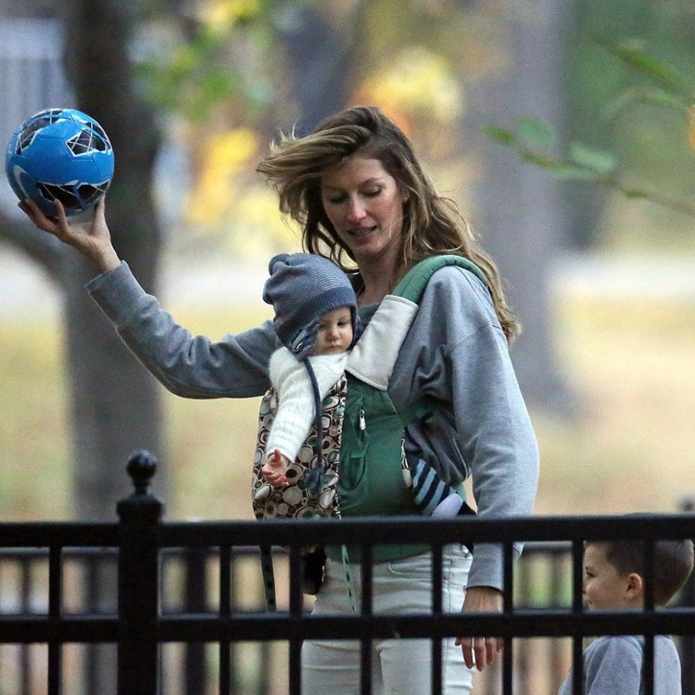 جيزيل بوندشين تحمل ابنتها وتلاعب أحد الأطفال