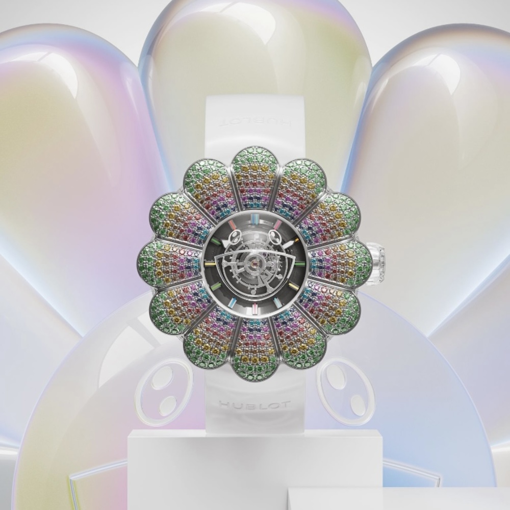 Hublot تقدم ساعة Takashi Murakami.. أول ساعة بتوربيّون مركزي سريع الحركة  ماريا شربل  قدّمت دار هوبلو Hublot ساعة MP-15 Takashi Murakami بتوربيّون مركزي سريع الحركة مصممة بالياقوت، فهذه القطعة فريدة من نوعها ويُمكن اعتبار التوربيّون المركزي تجسيدًا لسعي Hublot إلى إعادة تسليط الضوء على الساعات الراقية. وتم تصميم هذه الساعة لتعرض في مزاد Only Watch العلني، كما يُمكن تشبيه تصميم الساعة الدائريّة برسمة طفل صغير لزهرة الربيع باثنتي عشرة بتلة، ذات أطراف خضراء كدلالة على الأ