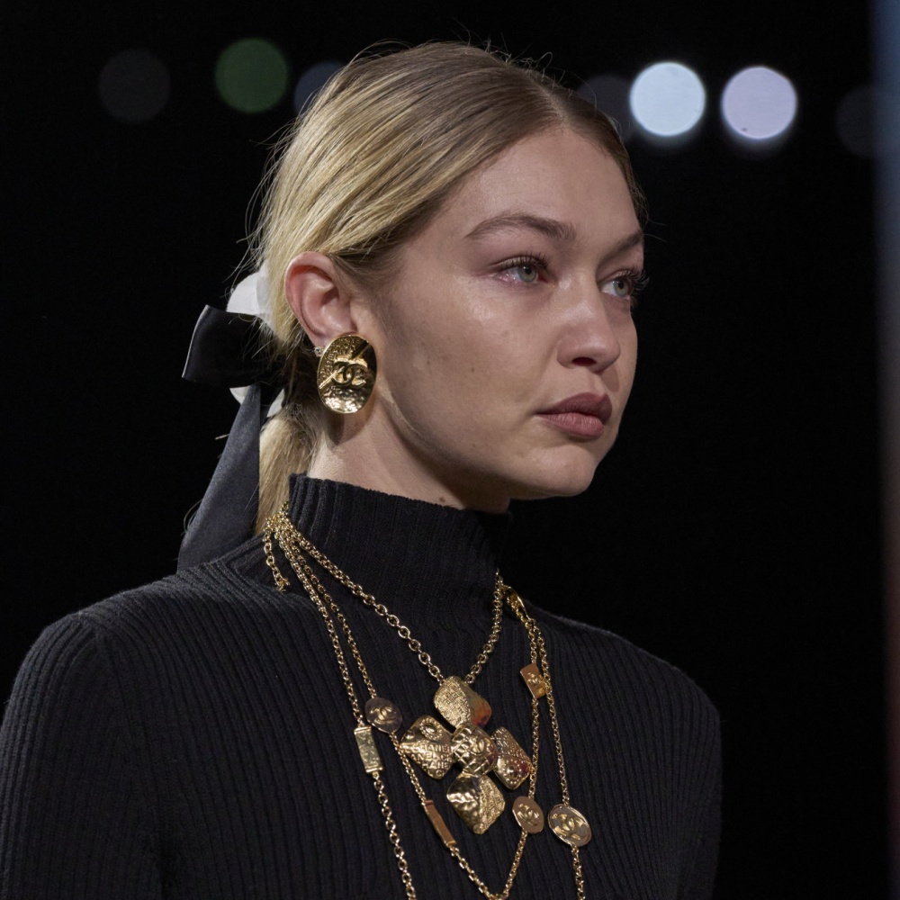 تسريحات شعر ذيل الحصان المنخفض مع أكسسوارات الورود والشرائط من دار CHANEL