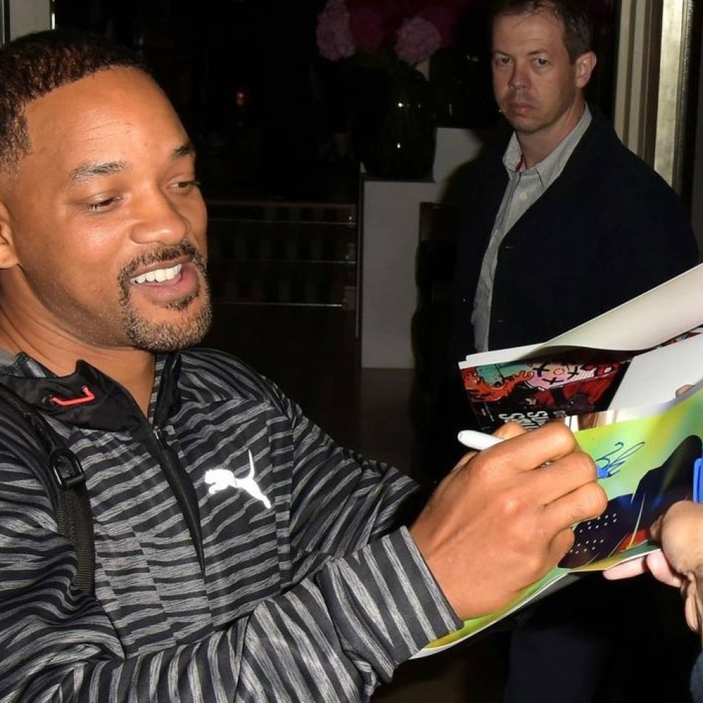 ويل سميث 47 عاما يقوم بالتوقيع لأحد معجبيه خارج الفندق الذي يقيم به في لندن