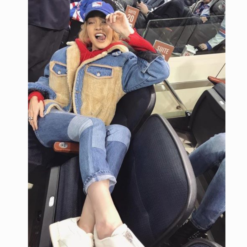 جيجي حديد تتخذ وضعية رشيقة أثناء تشجيعها لفريق نيويورك رينجرز في مباراة هوكي