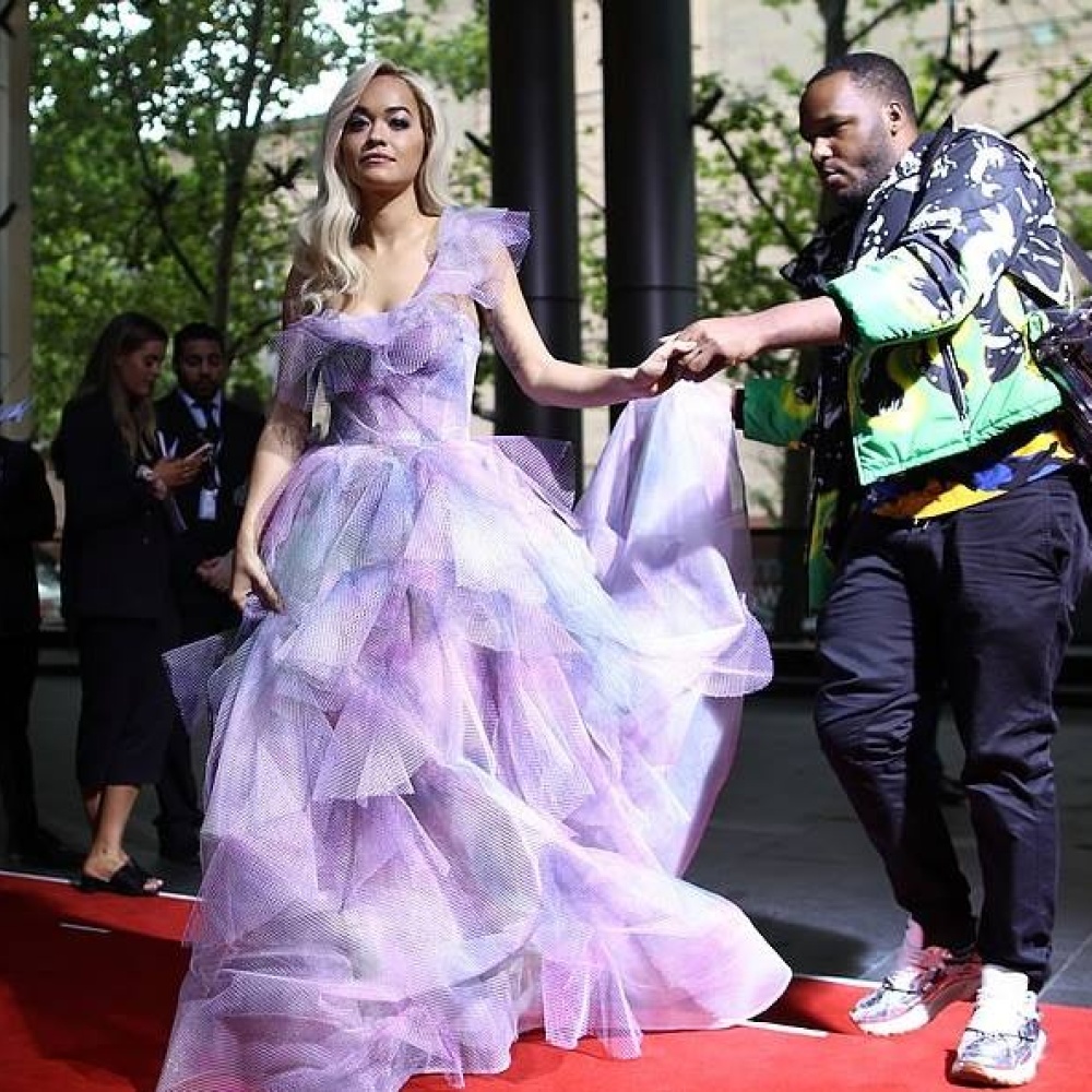 ريتا أورا تتلقى المساعدة من أحد المصورين لدى حضورها لحفل ARIA Award في سيدني