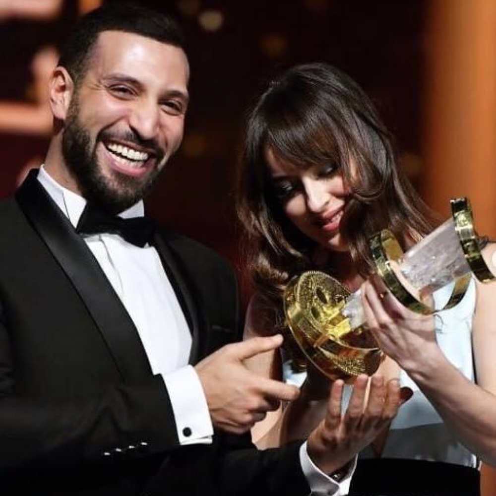 لقطة ضاحكة بين داكوتا جونسون والتونسي نضال السعدي أثناء تسليمه جائزة أفضل ممثل في اختتام مهرجان مراكش للفيلم