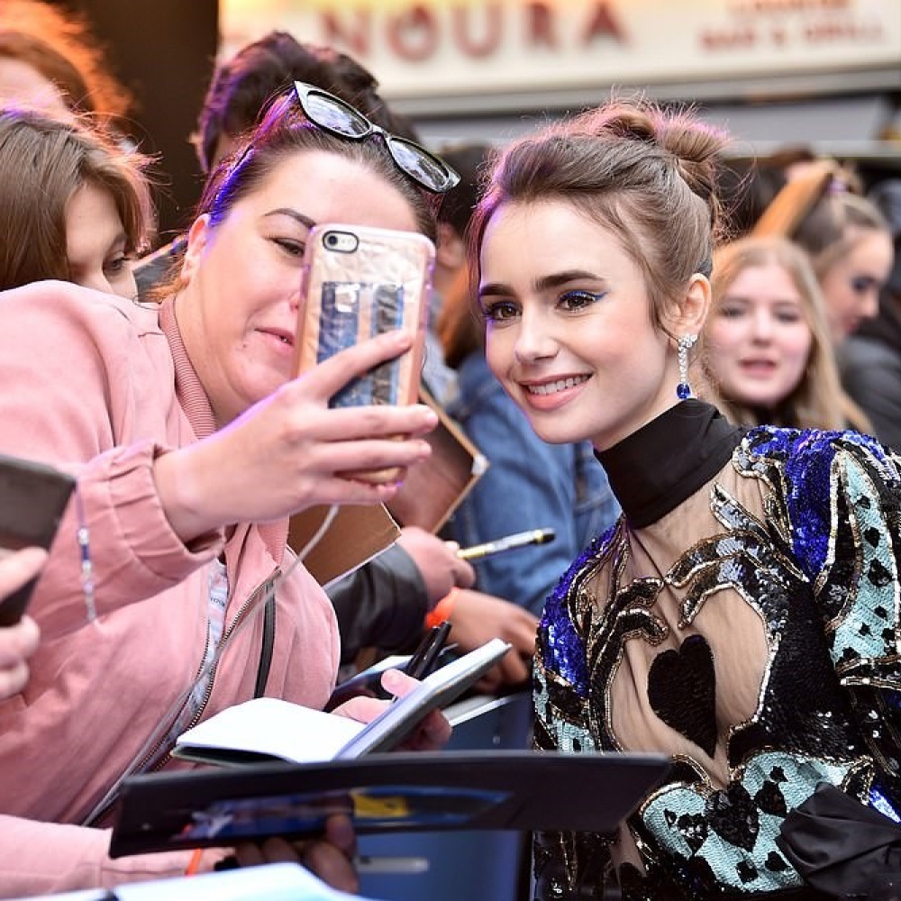 ليلي كولينز تلتقط صور السيلفي مع معجبينها على السجادة الحمراء في لندن