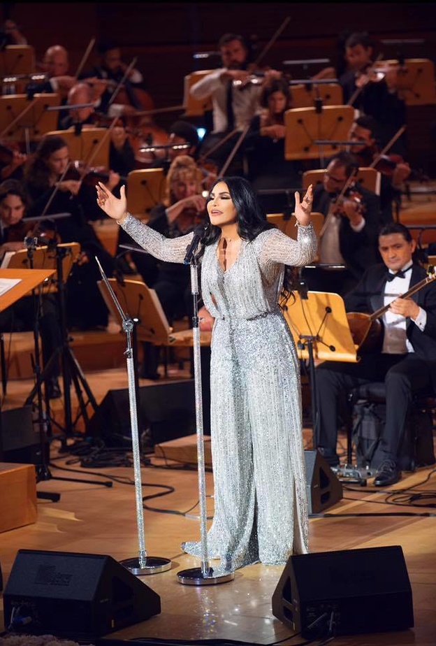 نسقت أحلام معطف مزين بالورود مع حزام جلدي على الخصر ونظارات شمسية كبيرة