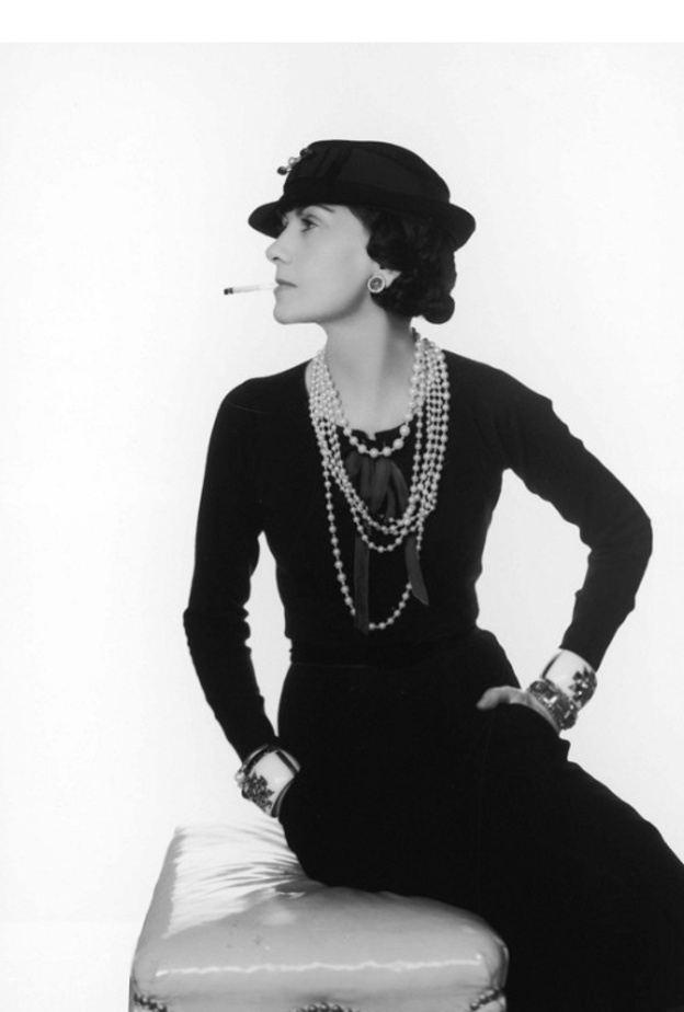 كوكو شانيل تقوم باضافة اللمسات النهائية على اطلالة عارضة الأزياء التي ترتدي طقم من التويد الشهير في المشغل الخاص بها عام ١٩٦٠