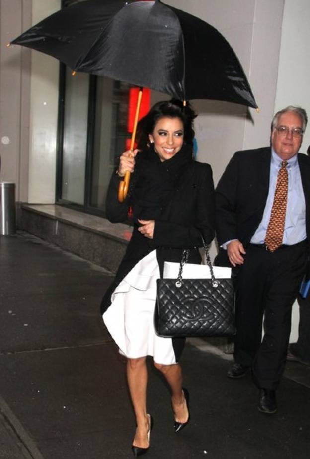 بالصور... إيفا لونغوريا تكافح البرد بالمظلة 