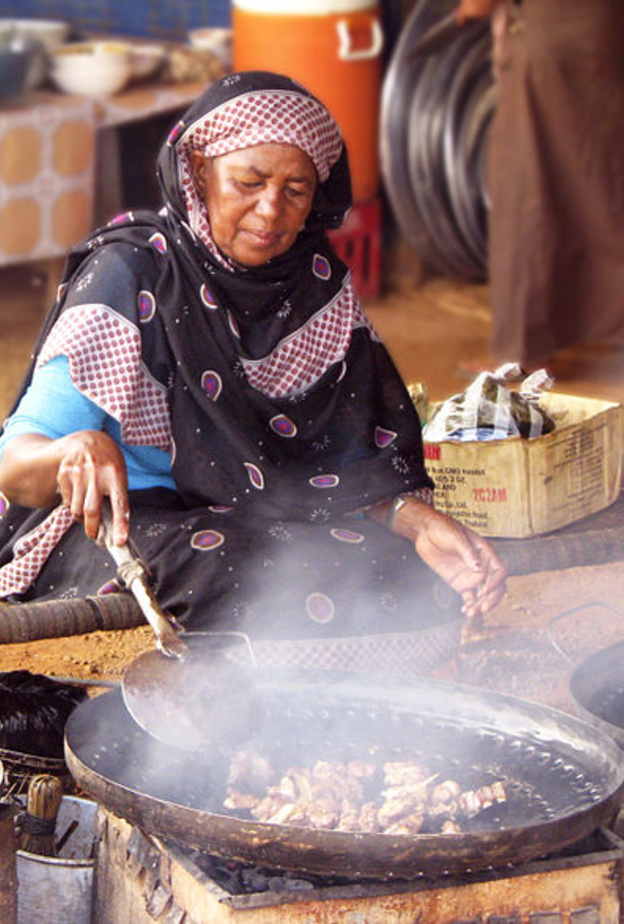 امرأة سودانية تطبخ