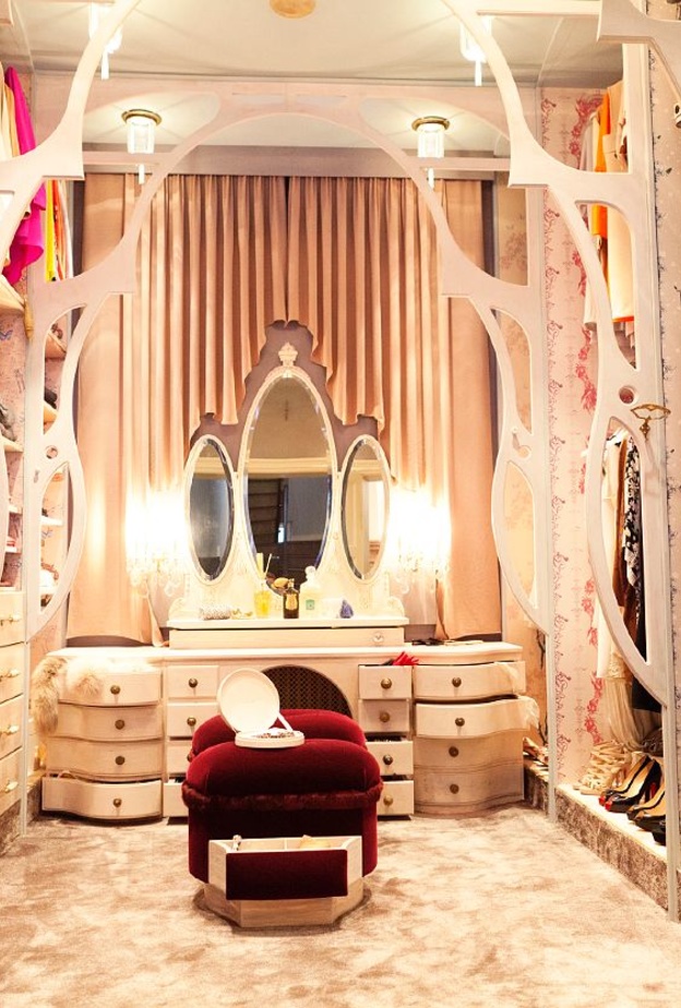 تصميم مميز لغرفة الملابس بأقواس خشبية و المقعد من المخمل الأحمر الذي يحتوي على جوارير  