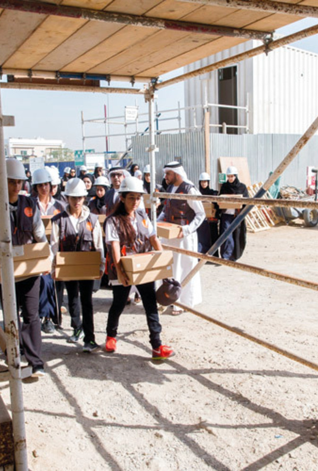 شما بنت محمد وطلاب مدارس في دبي يوزعون الطعام على العمال