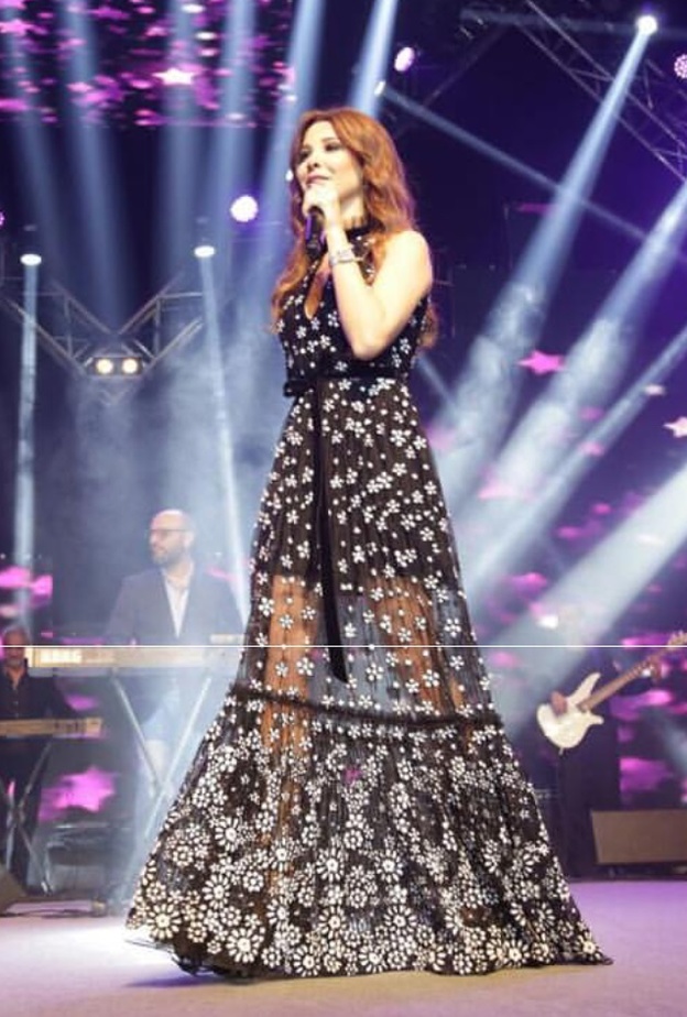 نانسي عجرم بفستان أسود مع أقمشة الموسلين الشفافة وتفاصيل نقشات الورود البيضاء