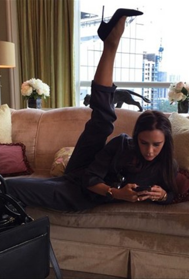 فيكتوريا بيكهام تمدد قدمها مرتدية الكعب العالي فيما تطالع هاتفها الجوال