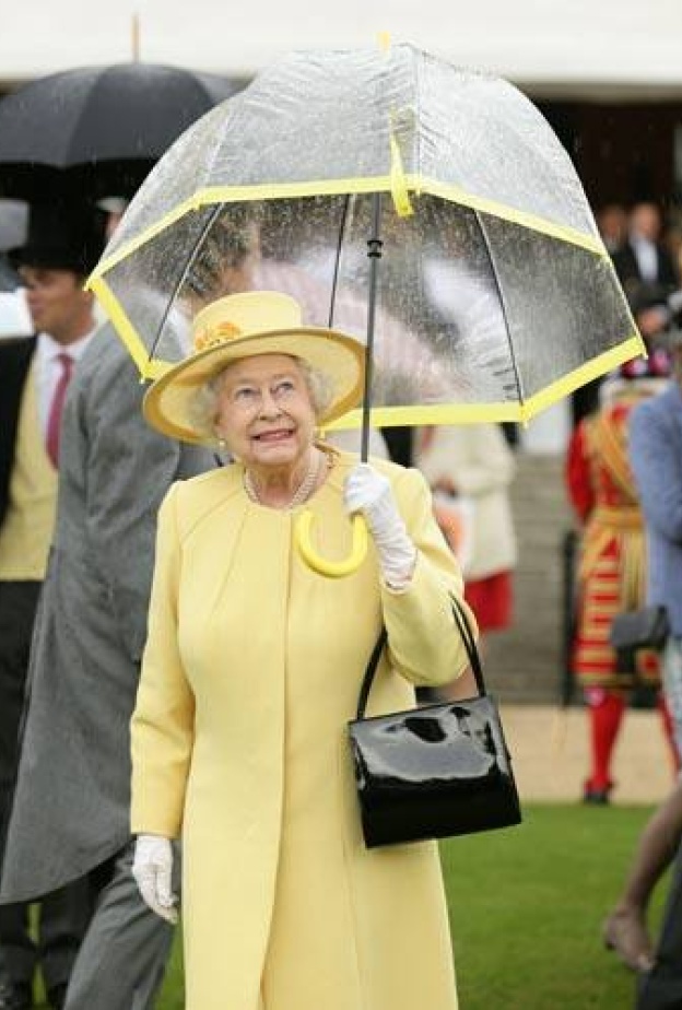 الملكة اليزابيث ممسكة مظلتها، ولسان حالها يقول : متى يتوقف المطر!