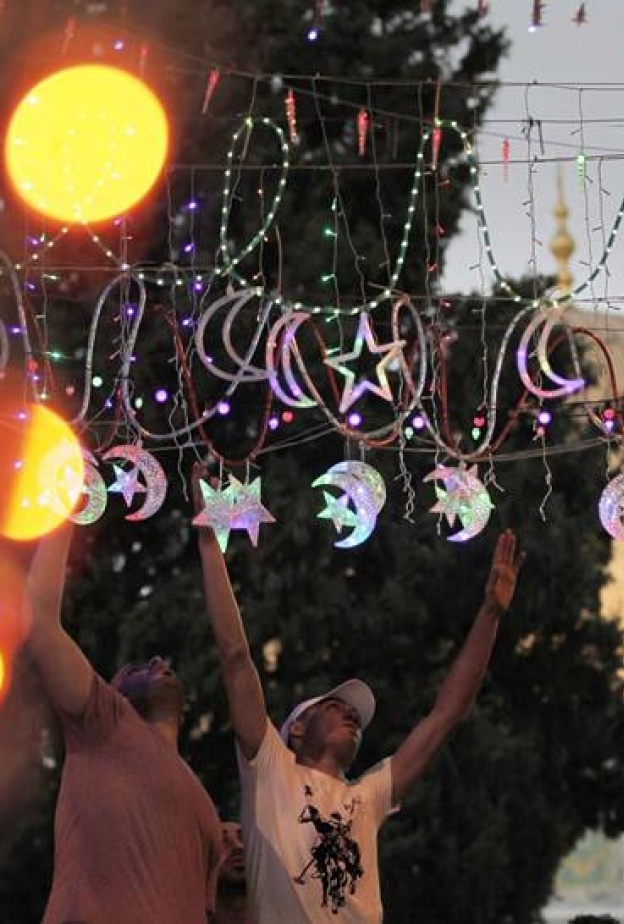 شباب يضعون اللمسات الأخيرة لزينة رمضان في القدس