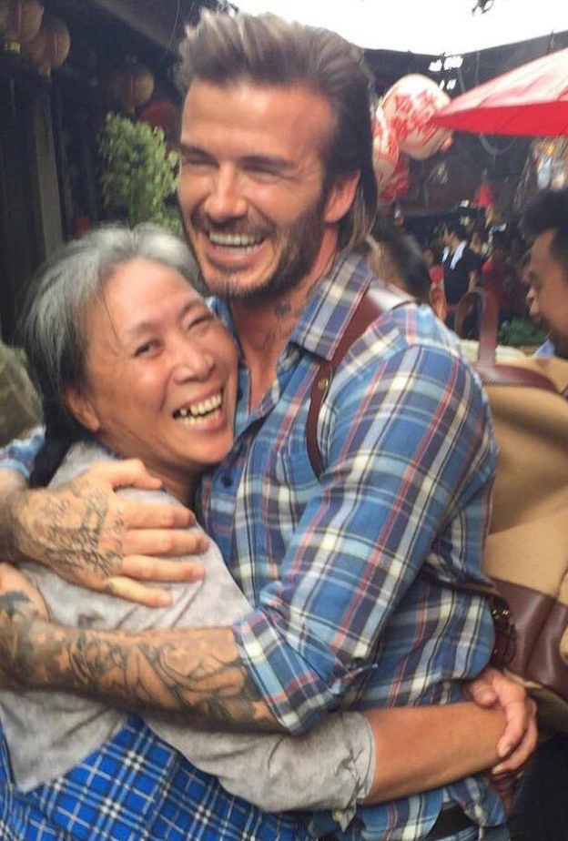 صورة طريفة لديفيد بيكهام محتضنا إحدى السيدات التايلنديات خلال زيارته الحالية لهناك