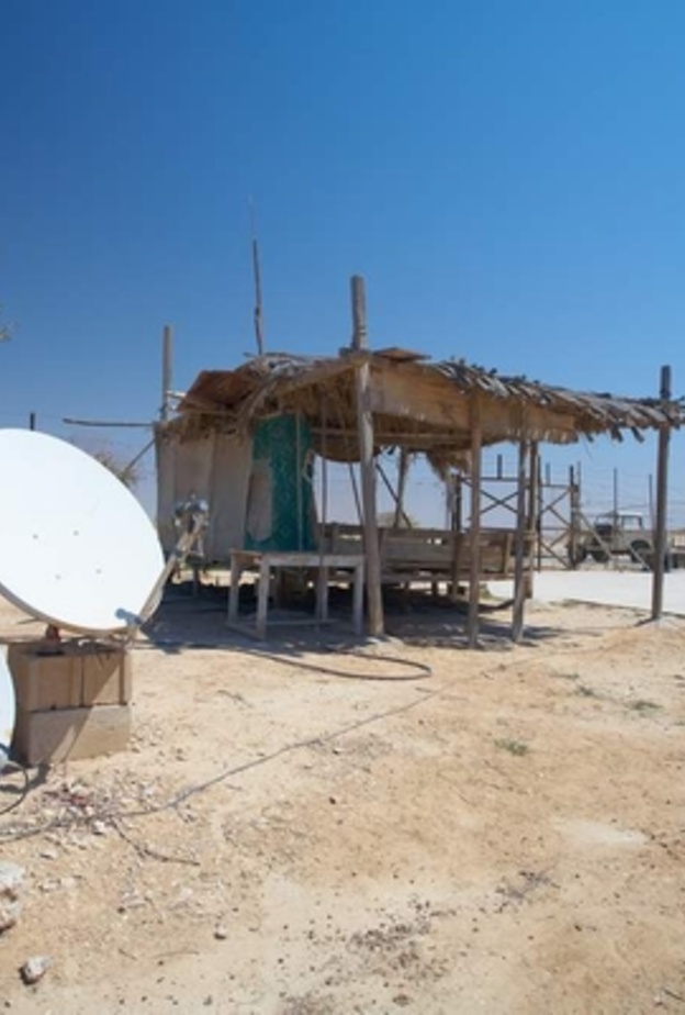 Rural communication through satellite dishes outside a dilapidated old dwelling