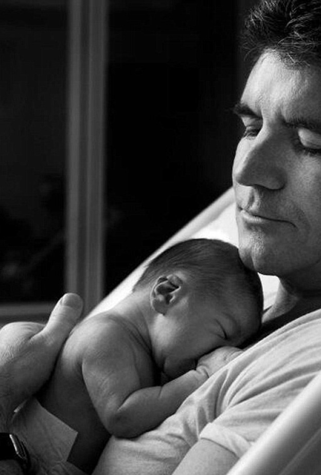  صورة تختصر كل حنان الأبو ة لسايمون كويل وهو يحتضن مولوده الجديد